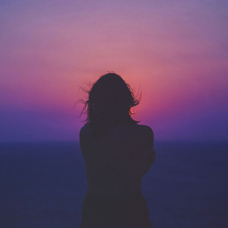 Silhouette of woman on pink horizon